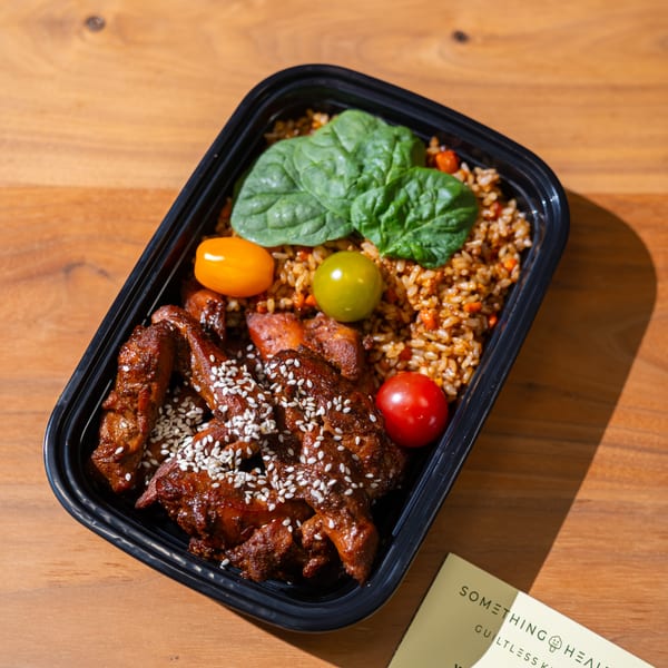 A Something Healthy Guiltless Kitchen meal prep container with chicken, rice, spinach, and tomatoes.